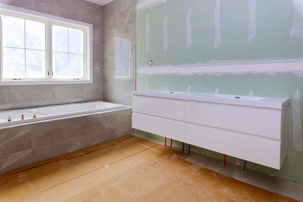Home construction bathtub tiled walls after installing remodeling master bathroom patching drywall